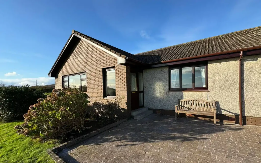 New roofline installation on frontle end of detached, harled, modern bungalow evening sunshine